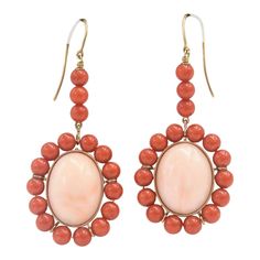 This is part of Chairish’s Fine Jewelry assortment.  These earrings feature a large oval cabochon angel skin coral piece measuring approximately  .80" x .60" set in a frame of orange coral beads measuring approximately 5.5 mm each.  The earrings dangle off an 18k yellow gold wire.  Pierced ears are required to wear these. Formal Coral Jewelry With Cabochon Details, Formal Coral Jewelry With Cabochon, Elegant Coral Oval Jewelry, Elegant Oval Coral Jewelry, Luxury Round Coral Jewelry, Vintage Oval Coral Jewelry, Vintage Coral Oval Jewelry, Coral Oval Jewelry For Gifts, Coral Oval Jewelry For Weddings