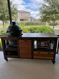 an outdoor bbq grill on top of a wooden table next to a large window