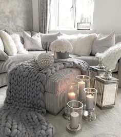 a living room filled with furniture and candles