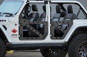 a white jeep with black leather seats is parked in front of a garage door and has the doors open