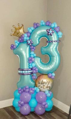 the number thirteen balloon is decorated with blue and purple balloons