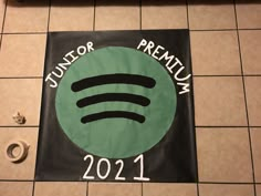 a green and black sign with the word junior premium next to it on a tile floor