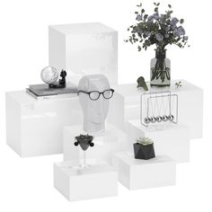 three white boxes with vases and flowers on them