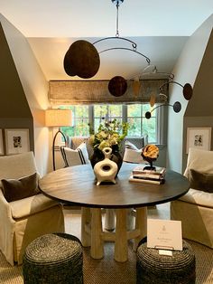 a living room filled with furniture and a round table in front of a large window