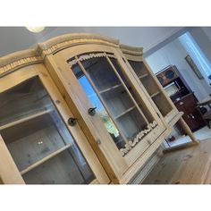 a wooden china cabinet with glass doors in a living room