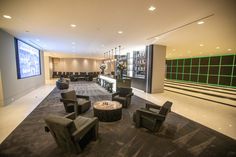 an empty lobby with chairs and tables in the center is lit up by green lights