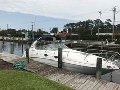 a white boat docked at a dock with other boats in the water