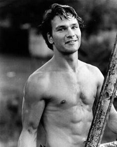 black and white photograph of a shirtless man holding a baseball bat in his right hand