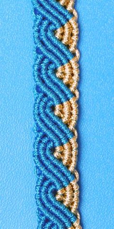 a blue and gold beaded bracelet on a blue background with an intricate design in the middle