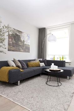 a living room filled with furniture and a painting on the wall above it's windows