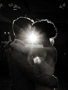 the bride and groom share their first dance at their wedding reception in black and white