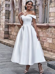 a woman in a white dress posing for the camera with her hand on her hip