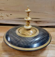 a wooden table topped with a black and gold candle holder