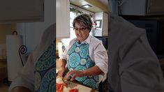 an older woman in glasses is cutting up food on a cutting board with a knife