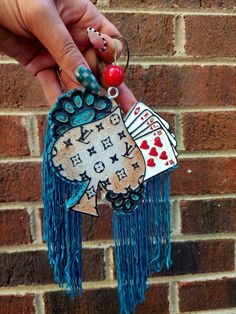 a person holding an ornament in front of a brick wall with writing on it