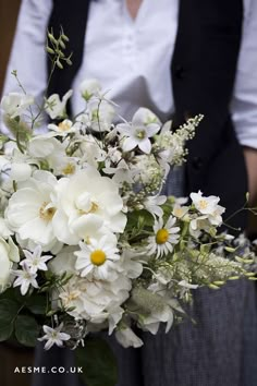 a woman holding a bouquet of white flowers