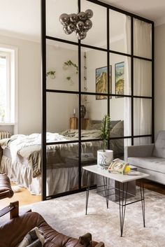 a living room filled with furniture and a large mirror on the wall above it's headboard