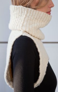 a woman wearing a white knitted cowl neck scarf