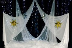 two white curtains with gold stars on them