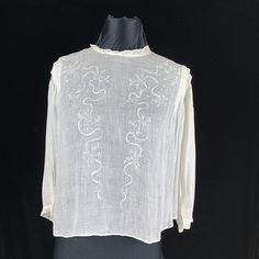 "This is a true Victorian blouse made of white lawn cotton fabric that is light as air. Embroidered ribbon motif and small round holes  decorate down the front with tucks at the shoulders and open cut work on the 3/4 sleeves that finish with lace.  The most important measurement on  Victorian clothing is the shoulder and length. Modern bodies are just larger than 100 years ago. This blouse is very roomy in front to fit 50\" but the back fits size 38\" bust. Length is 21\" but the waist should be Traditional Tops With Chikankari Embroidery For Daywear, Traditional Chikankari Embroidery Top For Daywear, Traditional Chikankari Embroidered Tops For Daywear, Off White Cotton Blouse For Daywear, White Chikankari Embroidery Blouse For Daywear, Victorian Cotton Tops For Spring, White Blouse With Floral Embroidery For Daywear, Elegant White Smocked Blouse, White Chikankari Embroidered Blouse For Daywear