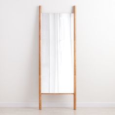 an empty white room with a wooden mirror