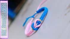 a blue and pink bracelet with two rings on it's end sitting on top of a table