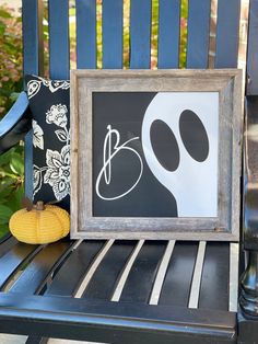 a black and white painting sitting on top of a blue chair next to a yellow pumpkin