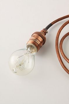 an old fashioned light bulb is attached to a brown cord with the words anthropologie written below it