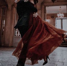 a man and woman are dancing on the dance floor in an old fashion photo with chandeliers hanging from the ceiling