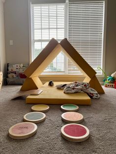 there are four plates on the floor in front of a window