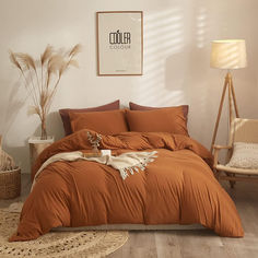 a bed with an orange comforter and pillows