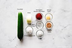 the ingredients to make cucumber soup laid out on a white marble counter top