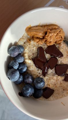 a bowl filled with oatmeal, chocolate and blueberries