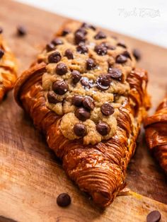 chocolate chip cookies and croissants on a wooden cutting board with coffee beans