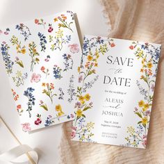 two floral save the dates cards on top of a blanket