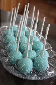 blue cake pops with white sprinkles on a glass plate