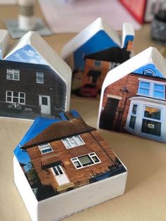 some houses are sitting on a table with one house cut out into the shape of it