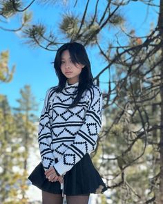 a young woman standing in the snow with her hands on her hips and looking at the camera