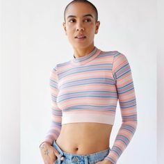 This Xs Urban Top Is A Stylish, Long-Sleeve Cropped Piece That Features A Vibrant Horizontal Stripe Pattern In Soft Pastels, Including Shades Of Pink, Blue, And White. The Ribbed Fabric Gives It A Textured Look, While The High Neckline Adds A Touch Of Sophistication. Perfect For Pairing With High-Waisted Jeans Or Skirts, This Top Combines A Playful Vibe With A Snug, Form-Fitting Silhouette, Making It Ideal For Casual Outings Or Layering Under Jackets. Multicolor Fitted Crop Top With Crew Neck, Urban Outfitters Pink Spring Top, Multicolor Fitted Cropped Top, Pink Urban Outfitters Tops For Spring, Fitted Multicolor Crop Top With Crew Neck, Urban Outfitters Crew Neck Crop Top, Fitted Pink Crop Top From Urban Outfitters, Fitted Pink Crop Top By Urban Outfitters, Striped Stretch Crop Top