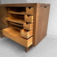 a wooden cabinet with drawers on the front and bottom shelves in different shapes and sizes