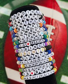 a stack of buttons with words written on them in front of a football field and ball