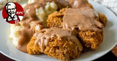 a white plate topped with fried chicken covered in gravy and mashed potatoes