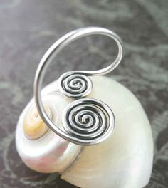 Material: 100% Sterling silver Weight: 1.5 grams Larger spiral is about 3/8 inch in diameter (9mm) Double spiral is more than 5/8 inch tall (17mm) Inside diameter is about 1/2 inch (15mm) Item number: wh303 This elegantly simple double spiral is created using just one long strand of sterling silver: It starts in the center of the smaller spiral, tightly swirling outward and counter-clockwise, and then creates the second larger spiral by swirling inward and in the opposite direction. In between t Silver Spiral Wire Wrapped Rings, Counter Clockwise, Wish Box, Feather Ring, Midi Ring, Midi Rings, Flower Of Life, Wrap Rings, Celtic Knot