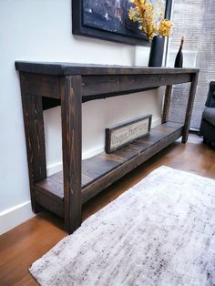 a wooden table sitting on top of a hard wood floor next to a white rug