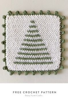 a crocheted christmas tree is shown on the side of a white and green wall hanging