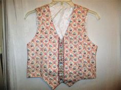 This is a 90s Vera Bradley cotton vest in their Pastel Pink retired pattern.  The vest has fabric covered buttons in front and an adjustable button tab belt in back.  It is lined with white polyester and has the Vera Bradley Designs green label.    It is in good condition with minor wear and no other problems to note. Tagged size S Chest - 38 flat inches around the outside underarms Length - 18 1/2 inches long down the back. 223 Spring Cotton Vest With Buttons, Summer Cotton Vest With Snap Buttons, Vintage Vest With Button Closure For Spring, Sleeveless Cotton Vest With Snap Buttons, Cotton Sleeveless Vest With Snap Buttons, Fitted Cotton Vest With Button Closure, Retro Cotton Vest With Buttons, White Cotton Vest With Buttons, Vintage Summer Vest With Button Closure