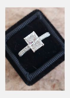 a diamond ring sitting on top of a velvet box