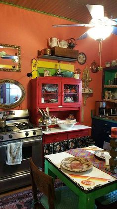 a kitchen with an old stove, table and chairs in front of the oven is brightly colored