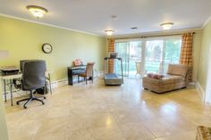 a living room filled with furniture and a flat screen tv mounted to a wall next to a sliding glass door