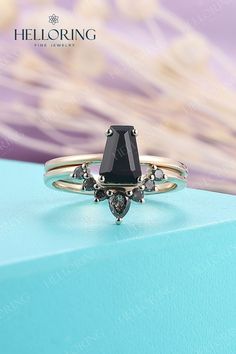 a black diamond ring sitting on top of a blue box